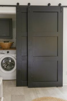 a washer and dryer in a room with sliding doors that lead to the kitchen