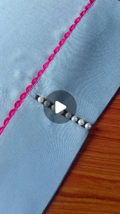 a close up of a piece of cloth with beads on it and a button in the middle