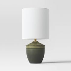 a green lamp with a white shade on it