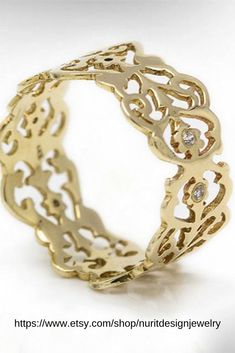 an intricate gold ring with diamonds on it