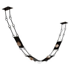 a long black chain with white beads hanging from it's ends and two small lights on the end