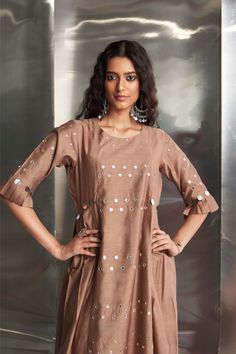 This Chanderi kurta in a beautiful ginger hue features mirror work on the front panel and sleeves, with stylish pleated sleeves adding flair. Paired with a Chanderi dupatta embroidered with mirror work along the borders, and wide-flare cotton palazzos highlighted with mirrors, this ensemble ensures a stylish and coordinated look. The bottom is elasticated with a drawstring for comfort. Anarkali Slub Silk Palazzo Set With Mirror Work, Slub Silk Anarkali Set With Mirror Work, Chanderi Sharara With Mirror Work And Straight Kurta, Designer Slub Silk Sets With Mirror Work, Slub Silk Palazzo Set With Mirror Work For Festivals, Mirror Work Slub Silk Palazzo Set For Festivals, Mirror Work Slub Silk Sets, Designer Anarkali Set With Mirror Work, Straight Kurta, Bollywood Style Slub Silk Palazzo Set With Mirror Work