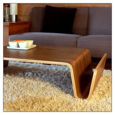 a coffee table sitting on top of a shaggy carpeted floor next to a couch