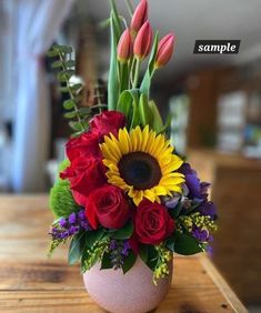 a vase filled with flowers on top of a wooden table