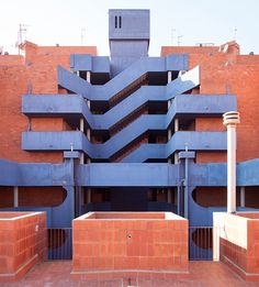 an apartment building with blue balconies and red brick walls on the outside wall