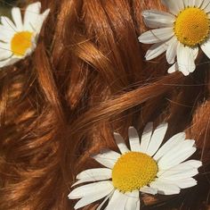 some white flowers on top of a red haired woman's head and long hair