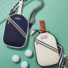 two bags and three golf balls on a green surface