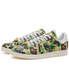 Find ADIDAS X Bape Stan Smith Sneakers on Editorialist. Lace up in a piece of streetwear history with these reimagined Stan Smith sneakers from adidas and BAPE’s latest collaboration. Wrapped in the iconic ABC Camo print, they pay homage to BAPE's coveted streetwear identity. Co-branded gold detailing feature throughout the anticipated design, forgoing the usual Stan Smith portrait for BAPE’s cult-favourite ape head on the tongue. A clean off-white sole underfoot rounds off the limited-edition r Adidas Custom Sneakers With Vulcanized Sole For Streetwear, Adidas Sneakers With Vulcanized Sole For Streetwear, Custom Lace-up Sneakers With Boost Midsole For Streetwear, Adidas Urban Sneakers With Laces, Adidas Low-top Sneakers For Streetwear, Urban Adidas Sneakers With Laces, Urban Adidas Sneakers, Urban Adidas Low-top Custom Sneakers, Urban Low-top Custom Adidas Sneakers