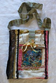 a handbag made out of fabric and other items on a white sheeted surface