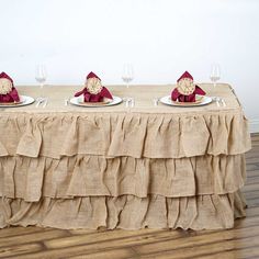 a table topped with plates and napkins covered in burlock next to wine glasses