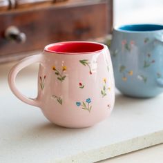 two coffee mugs sitting on top of a counter