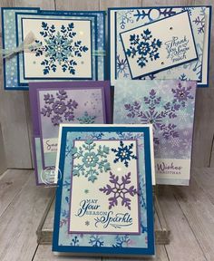 four cards with snowflakes on them, one is purple and the other is blue