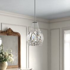 a chandelier hanging from the ceiling in a bedroom with white walls and furniture