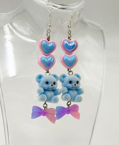 Add a touch of pastel goth cuteness to your outfit with these unique Blue Fuzzy Teddy Bear Kawaii Dangle Earrings! Featuring adorable heart beads and a sweet bow charm, these earrings are perfect for anyone who loves all things kawaii and cute. Stand out from the crowd with these one-of-a-kind accessories that are bound to make you smile every time you wear them. These handmade dangle earrings feature Cute AF fuzzy blue teddy bears adorned with pastel hearts and bows as sweet as candy. Get your thrillz on and add these one-of-kind earrings to your club wear collection. At Acid Thrillz, we value individuality and creativity by handmaking all items with care and saying F**k you to fast fashion by prioritizing quality and never creating duplicate items. Handmade Blue Kawaii Jewelry, Multicolor Heart-shaped Kawaii Jewelry, Kawaii Multicolor Heart-shaped Jewelry, Cute Heart Beads Dangle Jewelry, Kawaii Heart Earrings For Valentine's Day, Blue Kawaii Earrings For Gift, Cute Heart Bead Earrings For Party, Cute Dangle Heart Earrings, Cute Blue Earrings For Valentine's Day