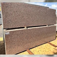 granite is stacked on top of each other in an outdoor area with yellow and white tiles