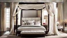 a canopy bed with white drapes and pillows on top of it in a bedroom