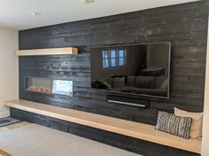 a flat screen tv mounted on the side of a wooden wall in a living room