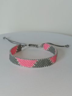 All my products are made of high quality Japanese Miyuki beads.  This hand-woven beaded bracelet will be a stylish gift for your girlfriend, wife or mother. You can easily combine it with your clothes for daily or special occasions.  harmony of gray and pink ❤️ The width of the beaded part is 13 cm and it has a slide lock for easy use. To ensure that you can use our products for a longer time, do not allow them to come into direct contact with perfumes and other chemicals. You can take a shower or swim with the wristband. Handmade Silver Friendship Bracelets With Round Beads, Adjustable Gray Jewelry With Colorful Beads, Minimalist Handmade Silver Beaded Bracelets, Handmade Bohemian Gray Beaded Bracelets, Resizable Silver Beaded Bracelets For Gifts, Handmade Gray Beaded Bracelets With Round Beads, Handmade Gray Beaded Bracelets, Handmade Silver Braided Bracelets With Round Beads, Adjustable Gray Bracelet With Silver Beads