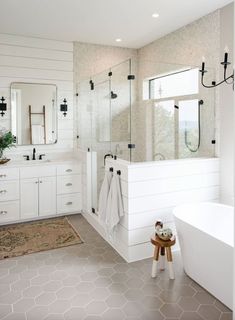 a white bathroom with two sinks and a bathtub