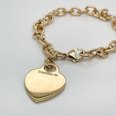 This is part of Chairish’s Fine Jewelry assortment.  A very fine Tiffany Co. bracelet.  In 18k gold.  With slightly oval links and a heart-shaped pendant charm.  The charm is not engraved.  Simply wonderful, classic Tiffany design!  Date: 20th Century  Overall Condition: It is in overall good, as-pictured, used estate condition with some very fine light surface scratches and other signs of expected light wear consistent with age.  Fineness: Marked 750 for 18k gold fineness.  Marks: Tiffany Co. / Luxury Engraved Oval Link Chain Bracelet, Classic Gold Heart Bracelet, Classic Bracelets With Logo Charm As A Gift, Engraved Classic Charm Bracelet, Classic Gold-tone Charm Bracelet, Elegant Engraved Oval Link Gold Bracelet, Elegant Engraved Gold Oval Link Bracelet, Elegant Gold Plated Chain Bracelet With Heart Charm, Luxury Gold-tone Tarnish Resistant Charm Bracelet