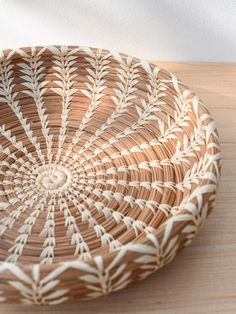 a woven basket sitting on top of a wooden table