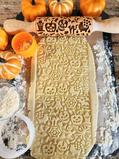 pumpkins and other ingredients are on the counter next to a cookie sheet with an intricate design