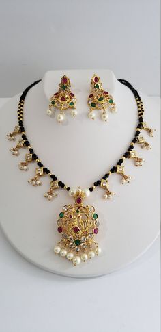 Mangalsutra is importance in Hindu culture and traditions. It is an ornament more specifically a necklace worn by women to signify marital status. Therefore, the groom tying the Mangalsutra around the bride's neck during the wedding rituals is considered a sacred Hindu custom. The American Daimonds and black beads combination necklace is unique and beautiful. The superior quality stones in these make this gorgeous Indian jewelry a must have jewelry. Each piece is handcrafted and made to orders. Black Beads Necklace Indian, Beads Necklace Indian, Indian Mangalsutra, Choker Patterns, Black Beads Necklace, Must Have Jewelry, Unique Gold Jewelry Designs, Silver Necklace Set, Necklace Indian