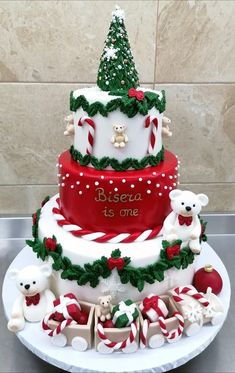 a three tiered christmas cake with teddy bears and candy canes on the bottom