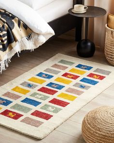 a colorful rug is on the floor next to a bed