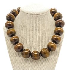 "Beautiful chunky brown wood bead necklace. This statement necklace is made with natural dyed and waxed large brown wooden beads. The necklace hangs 18\" long with a 2\" extender chain.     Details: *25 mm dyed & waxed wooden beads *Silver plated lobster clasp with 2\" extender chain Note:  **Please refer to size ranges and notes. Macro photography is used to show details but can make look larger than its actual size. If you have any questions regarding this item, please hit the \"Ask a Question Brown Bead Necklace, Wooden Bead Necklace, Brown Beaded Necklace, Wood Bead Necklace, Necklace Chunky, Wood Necklace, African Jewelry, Chunky Necklace, Naturally Dyed