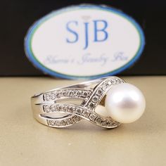 "Pearl & Diamond Ring Featuring a Genuine White Saltwater Pearl measuring approximately 7.8mm. Set in a 14k White Gold Braided band Full of Genuine sparkling white Diamonds, beautiful to complement a wedding dress. The Diamond total weight equals approximately .50 carats. A unique, bright white gold diamond statement ring, for any occasion. **Ring size: 6.5 **Pearls are the official June Birthstone. **Diamonds are an official April Birthstone. **This item can be sized up 2 sizes for an addit Elegant 14k White Gold White Ring, Classic Diamond Rings Aaa Quality, Aaa Quality Diamond Classic Rings, Fine Jewelry Pearl Ring With Round Band For Anniversary, Brilliant Cut Pearl Ring Fine Jewelry, Fine Jewelry Round Cut Pearl Ring For Anniversary, Fine Jewelry Pearl Ring With Brilliant Cut, Anniversary Pearl Ring With Round Band, Elegant 14k White Gold Rings With Round Stone