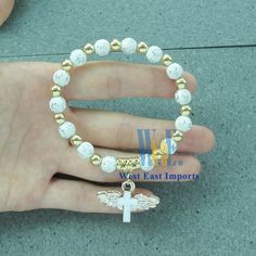 "Pack of 12 pieces of Angel Wing bracelets are absolutely stunning Favors for baptism, christening or church event. 12 Pcs WHITE ANGEL CHARM BRACELET - A meaningful and useful favor for Baptism and religious events. The Wings of angel adorn with a beautiful enamel cross. Each bracelet comes with a white organza gift bag Stretchy bracelet fits youth and adult wrists. Wood bead size 8mm, Charm size: .75\" x 1\", fits youth & adult" Angel Wing Bracelet, Angel Bracelet, Enamel Cross, Christening Favors, Angel Charm, Jewelry Board, White Angel, Baptism Favors, Doll Jewelry