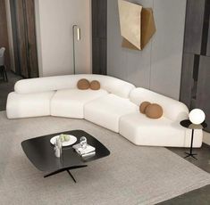 a white couch sitting on top of a rug in a living room next to a table