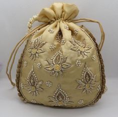 golden fabric kalash texture zardosi embroider wedding handmade handbag woman |embellish evening bag | indian potli bag purse handbagMaterial: SilkPackage Contents: As per quantity purchasedSize: 10” x 8”Designed with the heart, this beautiful Potli or batawa bag are eye catchy and made of premium material.Key Features:Embroidery art workThis potli is good match with both Indian and western outfits and are superb for wedding and festive partiesThis would be best complement to your designer saree Golden Fabric, Wedding Party Bags, Potli Bag, Handmade Handbag, Potli Bags, Handmade Handbags, Modern Embroidery, Designer Saree, Western Outfits