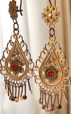 "A beautiful and elaborate pair of vintage cannetille earrings. These outstanding earrings are made of buttery 10k yellow gold (not marked but acid tested positive) and are crafted with fine cannetille wirework. Each earring is comprised of a two-dimensional link that is intricately layered and hangs from a decorative surmount. Delicate beadwork, twisted rope wirework, and swirled floral accents decorate the earrings and fringed accents dangle freely from the bottom. The surmounts have a complim Vintage Bronze Teardrop Earrings, Vintage Formal Filigree Chandelier Earrings, Antique Dangle Chandelier Earrings For Formal Occasions, Victorian Gold Plug Earrings, Antique Formal Dangle Chandelier Earrings, Vintage Yellow Gold Dangle Earrings, Formal Vintage Chandelier Earrings, Antique Metal Earrings For Evening, Vintage Brass Earrings For Evening