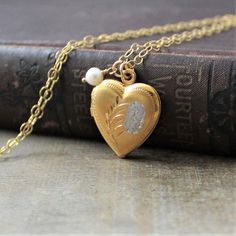 "This vintage locket is engraved with a floral design on the front; the reverse is plain. The gold filled heart opens revealing two compartments in which to place your favorite photos. The locket hangs from a new 14k gold filled cable chain accented with tiny freshwater pearl and finished with a lobster clasp. Locket 24x20mm Necklace length 18\" (45cm) ✦All of our vintage lockets ship with complimentary insurance✦ ✤Our entire selection of lockets can be found here✤ http://www.etsy.com/shop/Lexia Traditional Heart Jewelry For Wedding, Traditional Heart-shaped Jewelry For Weddings, Traditional Heart-shaped Wedding Jewelry, Heirloom Etched Jewelry For Wedding, Heirloom Etched Wedding Jewelry, Vintage Necklace With Engraving Option For Keepsake, Traditional Wedding Jewelry With Locket, Vintage Heart Charm Locket Necklace For Wedding, Vintage Locket Necklace With Heart Charm For Wedding