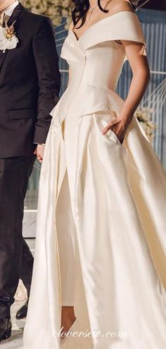 a man and woman in formal wear standing next to each other on the runway at a fashion show