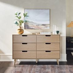 a wooden dresser sitting in a living room next to a wall with a painting on it