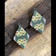 Handwoven Miyuki delica seed bead earrings in an original design created to celebrate the Wulfeni Spurge! This piece is brick stitched with metallic teal green, garnet, lime green, ivory and light gray luster beads. Measures around 1.5 inches in drop length and 1 inch wide and has hypoallergenic (nickel and lead free) brass hammered ear hooks in dark antique silver. For best care, store earrings flat when not wearing to retain shape of beadwork. Each earring is designed and handmade with love. Unique Handwoven Green Earrings, Traditional Green Handwoven Beaded Earrings, Traditional Green Beaded Earrings With Tiny Beads, Artisan Green Earrings With Tiny Beads, Traditional Green Earrings With Tiny Beads, Artisan Green Beaded Earrings With Tiny Beads, Artisan Green Dangle Beaded Earrings, Green Tiny Beads Jewelry For Crafting, Artisan Green Beaded Earrings As Gift