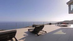 an empty patio with chairs overlooking the ocean