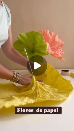 a woman is making flowers out of tissue paper