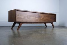 a wooden cabinet sitting on top of a cement floor