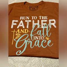 New Love In Faith Round Neck T-Shirt “Run To The Father And Fall Into Grace” Women’s Size Small Rust Color Orange With White And Turquoise Writing. Orange Brown Fall Seasons Season Love Thankful Grateful Blessed Yellow Faith Faithful Christian Witness Brown Letter Print T-shirt For Fall, Run To The Father, Faith Shirts, Christian Fall, Short Faux Fur Jacket, Blessed Shirt, Thankful Grateful Blessed, Leopard Print Jacket, Brown Fall