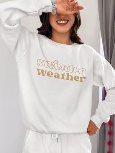 Bundle up, buttercup! Our "Sweater Weather" Sweatshirt is here to wrap you in a cozy embrace warmer than your ex's apology text. This isn't just a sweatshirt – it's a wearable ode to that magical time of year when leaves turn crisp and your dating standards turn flexible. Perfect for sipping pumpkin spice lattes, pretending to enjoy football, or aggressively cuddling your cat while scrolling through dating apps. With this sweatshirt, you're not just embracing autumn, you're practically french-ki Cotton Cozy Fit Sweater For Loungewear, Cozy Cotton Sweater For Loungewear, Winter Oversized Super Soft Tops, Trendy White Sweats For Leisure, Super Soft Sweatshirt For Fall, Winter Sweats Relaxed Fit Super Soft, Super Soft Comfortable Sweatshirt For Fall, Winter Sweats With Relaxed Fit And Super Soft Texture, Winter Sweats With Relaxed Fit And Super Soft