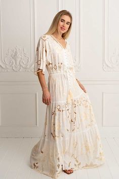 Meet the mesmerising Isla Kimono Dress in Ivory ~ a masterpiece that seamlessly weaves together sophistication and elegance, adorned with floral embroidered motifs contrasting in beige and our signature cut out work that creates delicate lace details throughout. Crafted from luxurious soft rayon our Isla Dress is captivating, a structural marvel designed to embrace your every move with grace. This beauty features an elastic drawstring waist as well as button-through bodice that can be worn open Cream V-neck Dress With Floral Embroidery, Elegant Maxi Embroidered Dress With Intricate Embroidery, Beige Lace Dress With Floral Embroidery, Beige Floor-length Dress With Intricate Embroidery, Floor-length Cream Dress With Intricate Embroidery, Chic Beige Floral Embroidery Dress, Cream Floor-length Dress With Intricate Embroidery, Beige Embroidered Lace Dress, Feminine Long Cream Dress