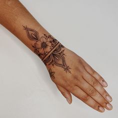 a woman's hand with a flower tattoo on it