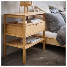 a bed with a wooden night stand next to it