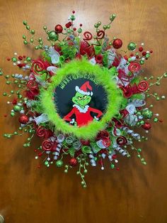 the grinch wreath is decorated with candy canes and greenery, as well as other holiday decorations