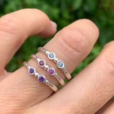 Wear them on their own or stacked all the way up your finger, our gemstone stacking bands in reclaimed sterling silver are the perfect addition to your daily jewels, a perfect gift for a loved one or yourself. Available in Ruby, Rhodolite Garnet, London Blue Topaz, Peridot, Amethyst, Blue Zircon, Spessartite Garnet, and Moonstone and mixed (pick your own stones) Each Stone measures approx 2.5mm. These beautiful pieces are handmade to order in Emily's Hudson Valley studio. Please allow 14-21 busi Adjustable Stackable Rings With Stones, Silver Stackable Rings With Round Gemstones, Silver Stackable Rings With Gemstone, Adjustable Silver Stackable Rings With Stones, Sterling Silver Stackable Rings With Bezel Setting As Gift, Everyday White Gold Stackable Rings With Birthstone, Silver Stackable Rings In Fine Jewelry, Adjustable Bezel Set Stackable Promise Rings, Adjustable Bezel Setting Stackable Rings For Promise