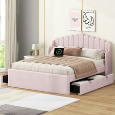 a bedroom with a pink bed and white rugs on the wooden floor, along with two framed pictures above it